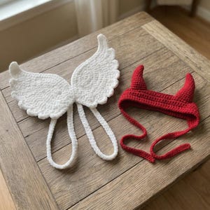 Puede incluir: Un conjunto de alas de ángel de ganchillo blanco con dos correas largas y una diadema de ganchillo roja con dos cuernos de diablo puntiagudos y dos lazos largos para sujetar el accesorio, ambos hechos de hilo suave con puntadas visibles.