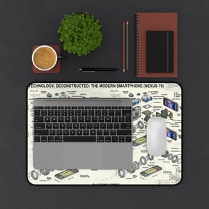 May include: A rectangular desk mat featuring a technical blueprint titled TECHNOLOGY, DECONSTRUCTED: THE MODERN SMARTPHONE (NEXUS-70) with detailed component illustrations, topped with a grey laptop and a white computer mouse.