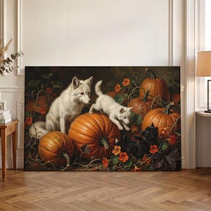 May include: A rectangular wall art print featuring a white fox sitting next to a white fox kit and a black kitten among several large orange pumpkins and orange nasturtium flowers. The scene is set against a dark, moody, and natural background.