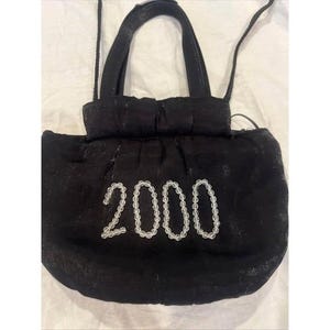 May include: A black handbag with a gathered top and two thin handles. The front of the bag features the number 2000 spelled out in clear, round beads. The fabric has a subtle, shimmering texture throughout the surface of the entire bag.
