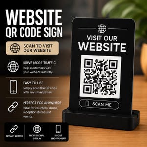 May include: A black rectangular sign with white text and a QR code, mounted on a black base. The sign features the text VISIT OUR WEBSITE and SCAN ME, accompanied by globe and smartphone icons. The design includes instructions for scanning the code.