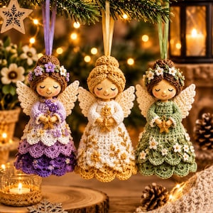 May include: Three crocheted angel ornaments hanging by ribbons. The left angel wears a purple dress with floral accents, the center angel wears a white and gold dress, and the right angel wears a green dress with white flowers. Each holds a small star.