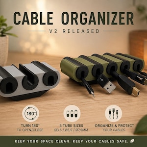 May include: A cable organiser set featuring one grey and black unit and one olive green and black unit with multiple slots. The text reads CABLE ORGANISER V2 RELEASED, TURN 180 TO OPEN/CLOSE, 3 TUBE SIZES 3.5MM/5.5MM/7.5MM, ORGANISE & PROTECT YOUR CABLES.