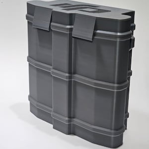 May include: A dark grey rectangular storage case with a textured finish and a rigid, ribbed exterior design. The top surface features the black DJI logo embossed in a recessed area. The case has two prominent latches on the front side.