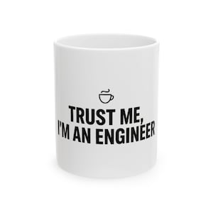 May include: A white ceramic mug featuring a small black line drawing of a coffee cup centered above the black text that reads, TRUST ME, I'M AN ENGINEER. The mug has a smooth, cylindrical body and a clean, minimalist design with bold lettering.