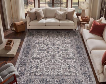 May include: A rectangular area rug featuring a detailed, symmetrical pattern in shades of charcoal gray, slate blue, and cream. The design includes a central medallion surrounded by intricate floral and geometric motifs with a wide decorative border.
