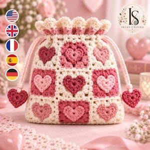 Può includere: Una pochette a sacchetto all'uncinetto con una griglia di quadrati color crema, ognuno contenente un motivo a cuore in rilievo in varie tonalità di rosa e rosso. La borsa presenta un bordo superiore arricciato e due cuori all'uncinetto.