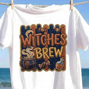 May include: A white short-sleeved t-shirt featuring an embroidered rectangular patch with a dark blue and orange striped background. The text "WITCHES BREW" is centred in orange, accompanied by a steaming cauldron, a spider, and a potion bottle.