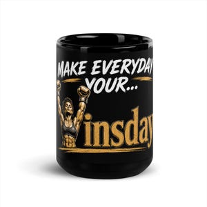 Può includere: Una tazza in ceramica nera con la grafica di un atleta muscoloso con le braccia alzate in segno di vittoria. Il testo recita "MAKE EVERYDAY YOUR..." in bianco e "insday" in oro, con pennellate dorate orizzontali che decorano la tazza.