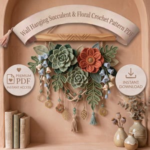Peut inclure: Un modèle de crochet PDF pour tenture murale présentant un arrangement décoratif de succulentes vertes, une fleur couleur rouille et des fleurs en forme de cloche bleu clair. Le design inclut des cordons avec perles et pompons.