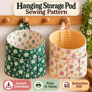 Op de afbeelding: Twee hangende opbergmanden met naaipatroon. De linker mand is donkergroen met witte madeliefjes, de rechter is crème met oranje en roze bloemen en een geel ruitjespatroon aan de binnenkant. Tekst: Hanging Storage Pod Sewing Pattern.
