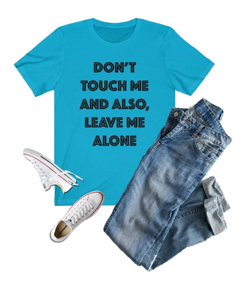 May include: A turquoise blue t-shirt with the text "Don't touch me and also, leave me alone" printed in black.