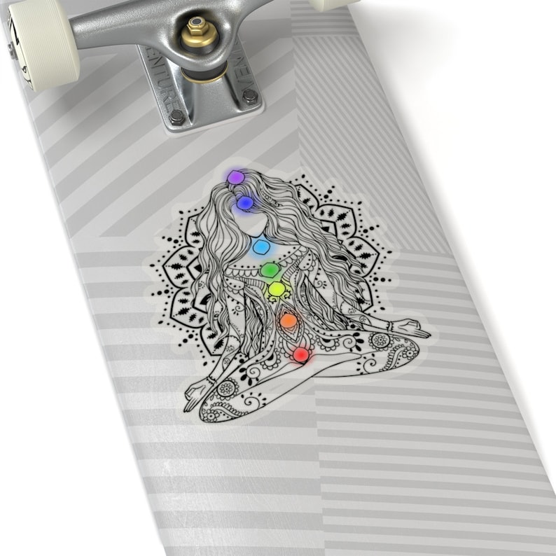 May include: A black and white illustration of a woman meditating with a mandala behind her. The woman has seven chakras represented by colored circles along her spine.