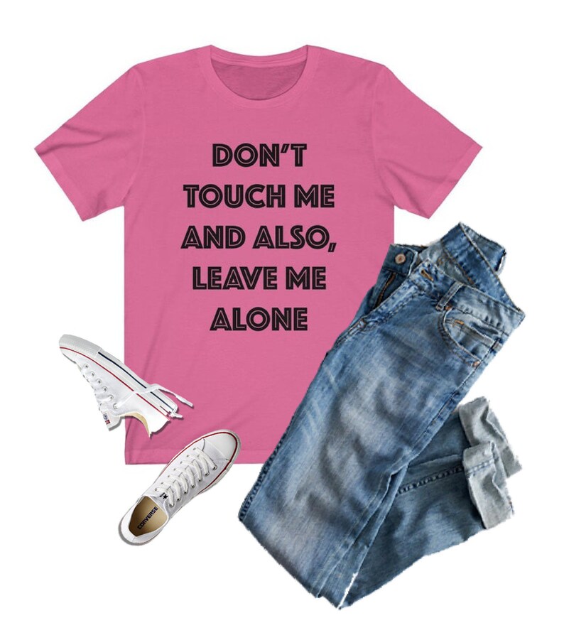 May include: Pink t-shirt with the text "DON'T TOUCH ME AND ALSO, LEAVE ME ALONE" in black outlined letters.