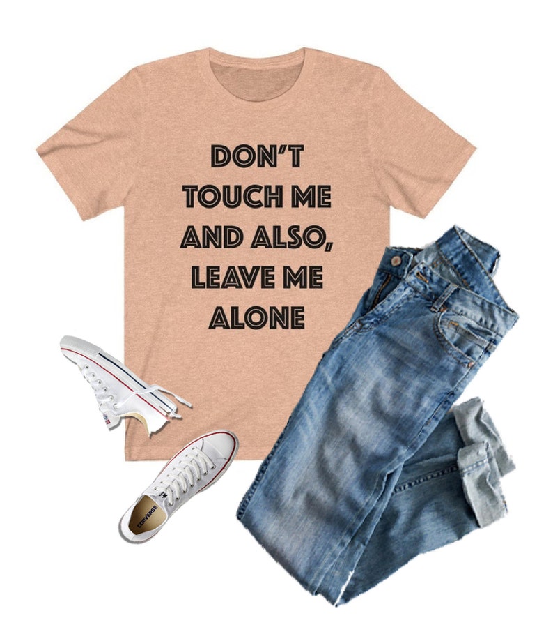 May include: A peach-colored t-shirt with the text "DON'T TOUCH ME AND ALSO, LEAVE ME ALONE" printed in black.
