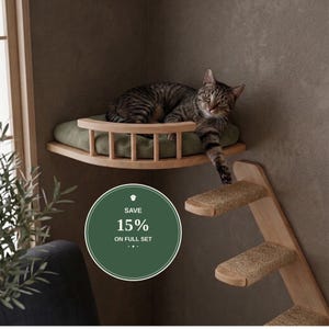 May include: A wall-mounted wooden cat perch with a curved railing and a soft olive green cushion, accompanied by a set of three wooden steps with textured beige carpeted treads. A circular green graphic displays the text SAVE 15% ON FULL SET.