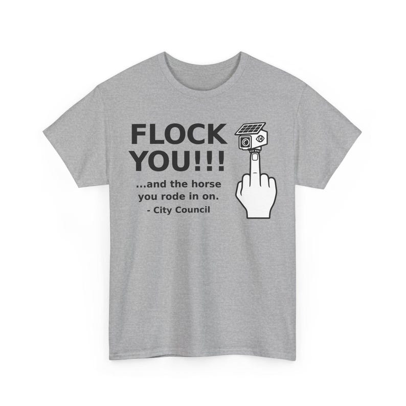 May include: A heather gray t-shirt featuring black text that reads FLOCK YOU!!! ...and the horse you rode in on. - City Council. Next to the text is a graphic of a hand making an obscene gesture with a security camera mounted on the middle finger.