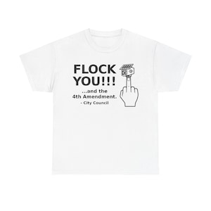 Puede incluir: Una camiseta blanca con un gráfico negro de una mano haciendo el gesto del dedo medio con una cámara de seguridad solar en la punta. El texto dice: FLOCK YOU!!! ...and the 4th Amendment. - City Council, impreso en letras negras.
