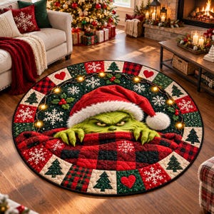 Könnte beinhalten: Ein runder Steppteppich mit einer grünen Figur in roter Weihnachtsmütze, die über einer rot-schwarz karierten Decke hervorschaut. Der Rand zeigt ein Muster aus Schneeflocken, Tannenbäumen, roten Herzen und kleinen gelben Lichtern.