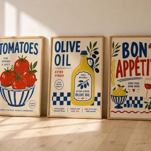 May include: A set of three framed wall art prints featuring culinary themes. The first print shows red tomatoes in a blue and white bowl with the text TOMATOES. The second shows a yellow olive oil bottle with the text OLIVE OIL. The third shows the text BON APPETIT with a wine glass and lemons.