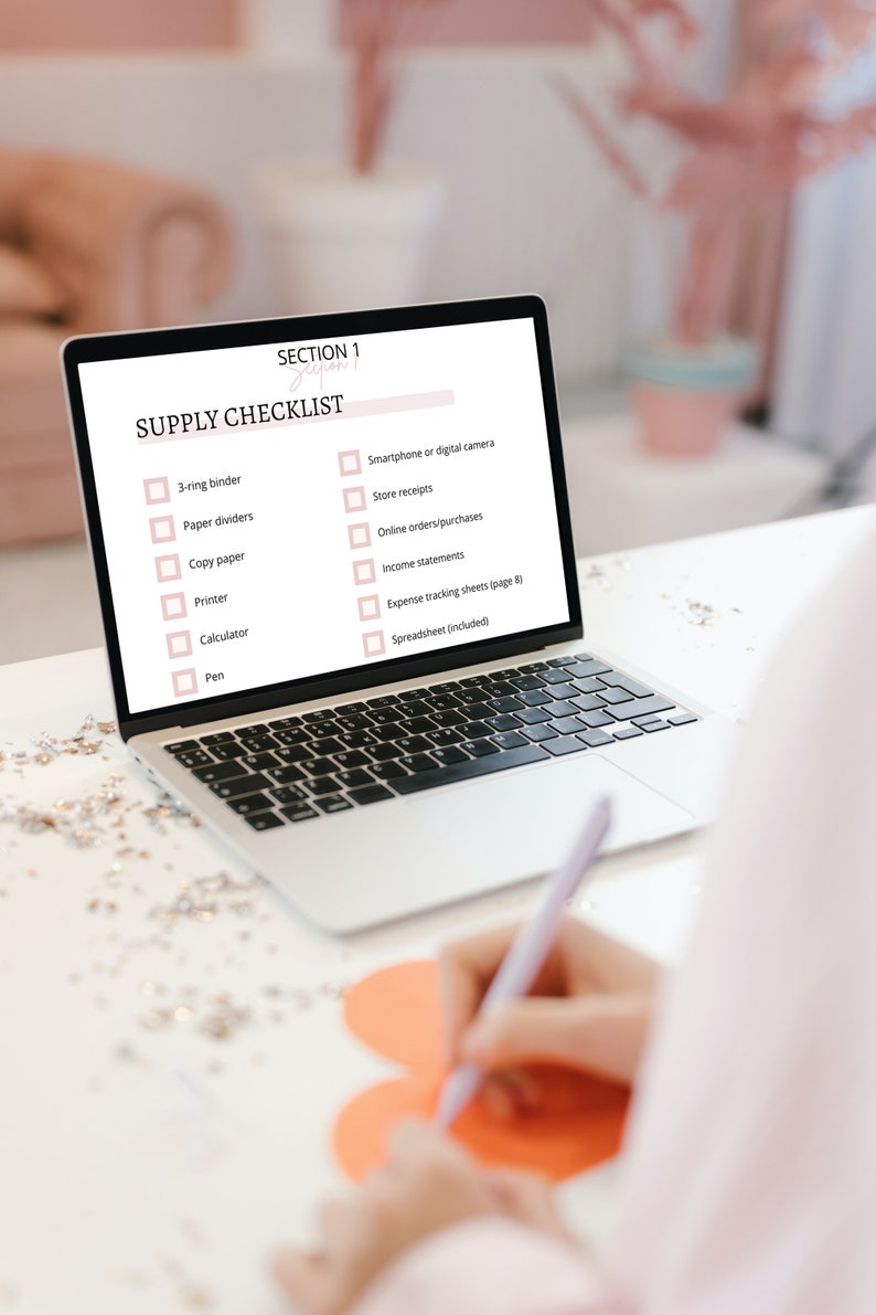 May include: A laptop computer screen displays a checklist titled "Supply Checklist" with a list of items needed for a business, including a 3-ring binder, paper dividers, copy paper, a printer, a calculator, a pen, a smartphone or digital camera, store receipts, online orders/purchases, income statements, expense tracking sheets, and a spreadsheet.