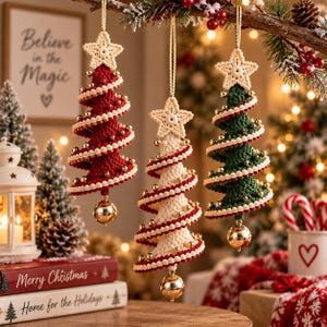 May include: Three spiral-shaped Christmas tree ornaments made of crocheted yarn in red, cream, and dark green. Each tree is topped with a cream-colored crocheted star, features a gold bell at the base, and is decorated with small gold beads.