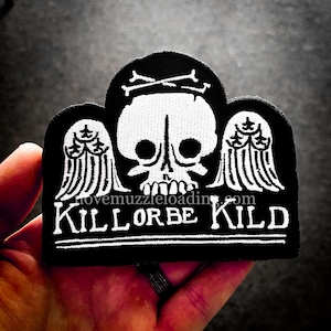 May include: Black and white embroidered patch with a skull with wings and the text "KILL OR BE KILLED".