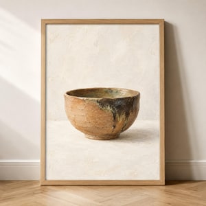 May include: A framed wall art print featuring a textured, round ceramic bowl with a tan, earthy base and a dark, mottled brown glaze dripping down one side, set against a neutral, off-white, painterly background with visible brushstrokes.