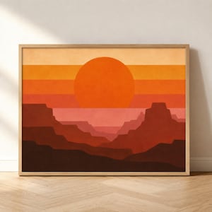 May include: A framed rectangular wall art print featuring a stylized desert landscape with layered horizontal bands of color. A large orange sun sits above dark red and brown canyon silhouettes, set against a light beige and peach sky background.