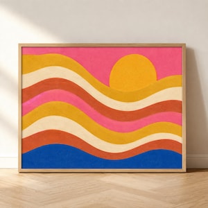 May include: A rectangular wall art print in a light wood frame featuring a horizontal landscape design with wavy bands of pink, yellow, cream, and orange. A large, solid yellow circle representing the sun sits in the upper right corner.