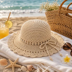 May include: A beige crocheted sun hat featuring a rounded crown and a wide, scalloped brim. The hat is accented with a matching crocheted cord tied into a bow at the front, with two dangling ends finished with small wooden beads at the tips.
