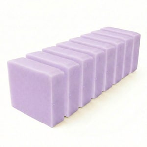 May include: A row of eight rectangular bars of solid lavender-colored soap arranged in a diagonal line. Each bar has a smooth, matte finish and uniform shape, creating a clean and consistent appearance for these individual personal care items.