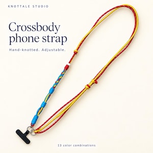 May include: A hand-knotted, adjustable crossbody phone strap featuring red and yellow cords, a braided section in blue, yellow, and red, and a black attachment tab. Text reads: KNOTTALE STUDIO, Crossbody phone strap, Hand-knotted. Adjustable., 13 color combinations.