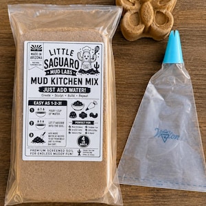 May include: A 1.8 kg brick of Little Saguaro Mud Kitchen Mix in a clear plastic bag with instructions, a brown butterfly-shaped mud mould, and a clear piping bag with a blue plastic tip. The label text includes Made in Arizona and Just Add Water.