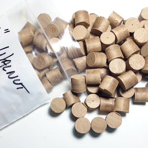 May include: A bag of 1/8 inch walnut wood dowels. The bag is labeled "1/8" Walnut" and "Tapered". The dowels are a light brown color and are scattered on a white surface.