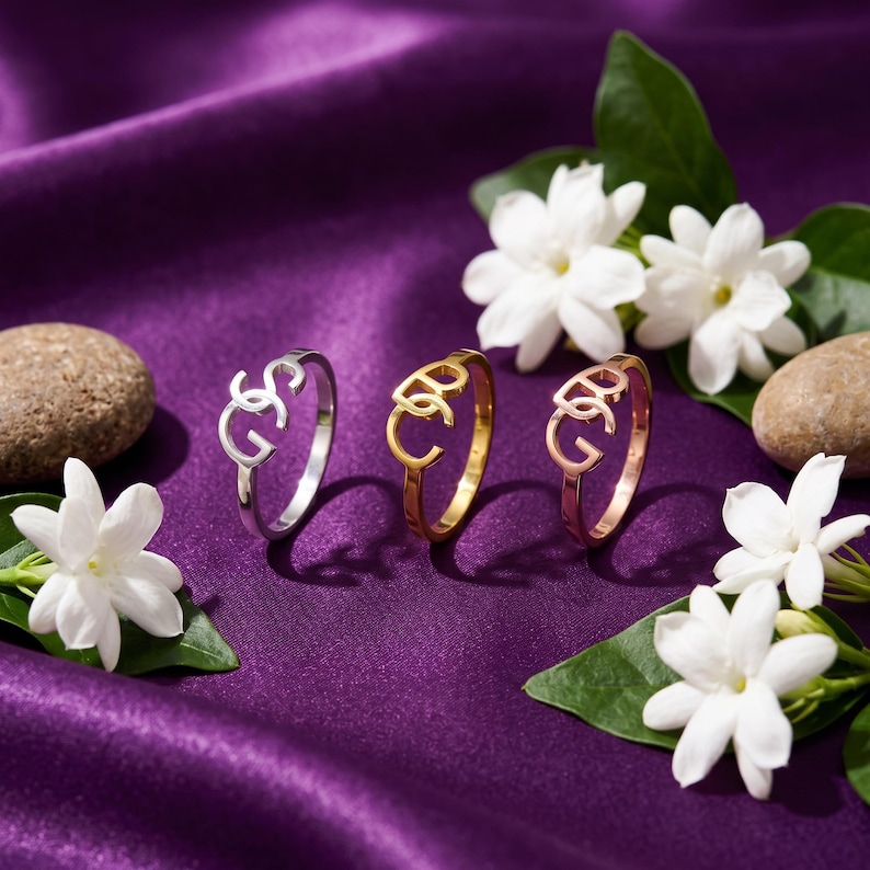 Purple satin display showing three interlocking initial ring finishes, custom two initial ring options