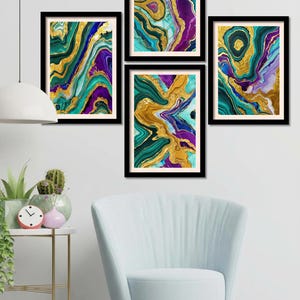 May include: A set of four framed wall art prints featuring abstract fluid marble patterns in shades of deep purple, teal, emerald green, and metallic gold. Each rectangular print is encased in a thin black frame with a light cream border.