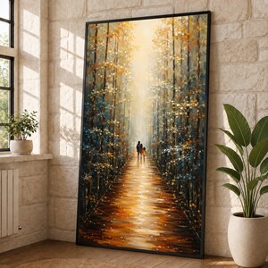Könnte beinhalten: Ein vertikaler gerahmter Wandkunstdruck, der einen Pfad durch einen Wald mit hohen Bäumen in Gold-, Orange- und Dunkelblautönen zeigt. Zwei kleine Figuren gehen auf dem leuchtenden, reflektierenden Weg in Richtung eines hellen Horizonts.