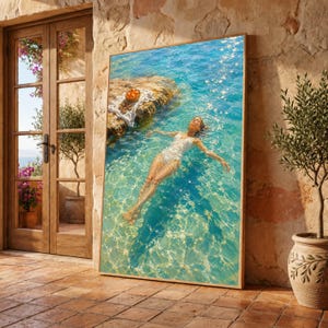 Puede incluir: Una impresión de arte mural vertical enmarcada que muestra a una persona con traje de baño blanco flotando de espaldas en agua turquesa clara. Cerca de una roca, un paño blanco sostiene un cuenco de naranjas. Estilo pictórico brillante.