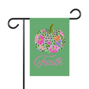 May include: A rectangular garden flag with a green background featuring a central pumpkin illustration. The pumpkin has a green stem and a pattern of leopard spots mixed with pink, orange, and purple flowers. The word Faulk is written in pink script.