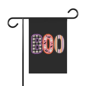 Peut inclure: Un drapeau de jardin rectangulaire noir suspendu à un support en métal noir. Le drapeau affiche le mot BOO en grandes lettres. Le B est à carreaux noirs et blancs, le O est rose avec des fantômes blancs et des chauves-souris noires, et le O final est rayé.