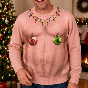 May include: A light pink long-sleeve jumper featuring a realistic print of a hairy torso. The design includes a string of colourful Christmas lights around the neckline and two hanging Christmas ornaments positioned over the chest area.