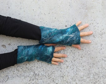 May include: A pair of teal blue fingerless gloves with white stitching and a marbled pattern.