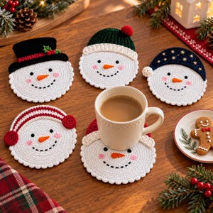 May include: Five round, white crocheted snowman coasters with embroidered faces, orange noses, and pink cheeks. Each features a different winter accessory: a black top hat, a green beanie, a dark blue cap, red earmuffs, and a red hat.