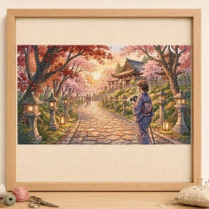 May include: A framed cross-stitch embroidery depicting a stone path leading to a temple, lined with stone lanterns and cherry blossom trees. A person in a kimono stands on the path holding a camera, with other figures walking in the distance.