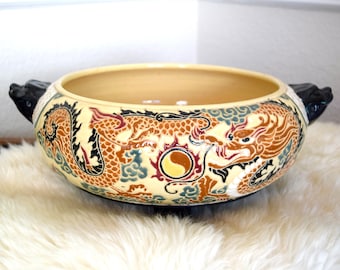 Vintage Asian planter featuring dragons and a flaming pearl and foo dog or guardian lion handles.