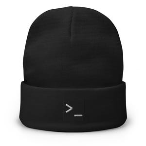 Puede incluir: Un gorro negro liso con dobladillo que presenta un pequeño gráfico bordado en blanco centrado en la parte frontal del dobladillo. El bordado representa un símbolo de línea de comandos con un signo de mayor que y un guion bajo.