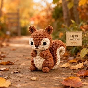May include: A brown and cream-coloured crocheted squirrel toy with large black eyes and a bushy tail. A rectangular tan label with the text Digital Download is positioned to the right of the squirrel, featuring a small leaf graphic below the text.