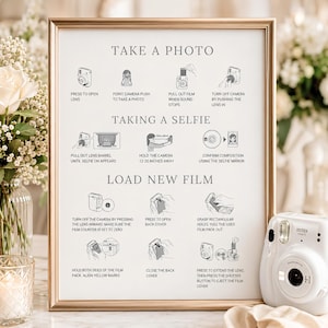 May include: A framed instructional sign with black text and line drawings on a white background. It provides step-by-step directions for taking a photo, taking a selfie, and loading new film into an Instax camera, including a 12-20 inch distance guide.