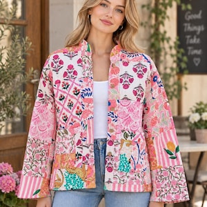 May include: A long-sleeve quilted jacket featuring a patchwork design with various floral, striped, and animal prints in shades of pink, white, orange, and blue. The jacket has a mandarin collar, a button-down front with wooden buttons, and wide sleeves.